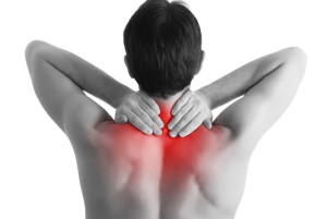 Rear view of a young man holding her neck in pain, isolated on white background, monochrome photo with red as a symbol for the hardening